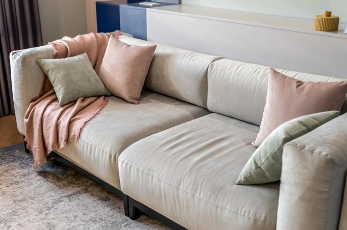 Centralne miejsce w salonie wziął duży miękki sofa z poduszkami w objętości jasnoszarym tapicerki. On nie rozumie, ale rozmiary można go używać w pełnym łóżko dla jednej osoby.