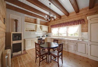 Kuchnia w stylu prowansalskim z drewnianymi podłogami i belkami stropowymi.